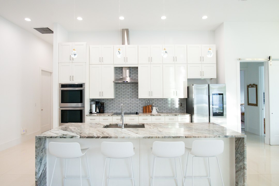 A clean, modern luxury kitchen with bright lighting, sleek countertops, and high-end appliances, showcasing a high-value home feature.