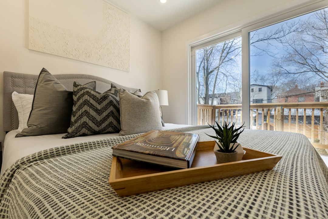 A professionally staged master bedroom with a serene, neutral color palette, ample natural light, and tasteful decor, creating an inviting space for potential buyers.